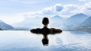 蒂鲁罗Hotel Gartner的坐在水中的女人,看着群山