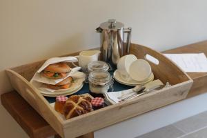 een houten dienblad met een broodje en gebak op een tafel bij Cwmbach Lodge luxury B&B in Glasbury