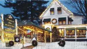a white house with christmas lights in front of it at Woodstock Inn, Station and Brewery in North Woodstock