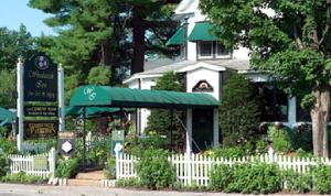 a white picket fence in front of a house at Woodstock Inn, Station and Brewery in North Woodstock