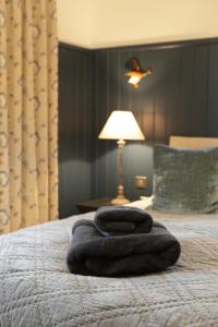 a pile of towels sitting on top of a bed at Cwmbach Lodge luxury B&B in Glasbury