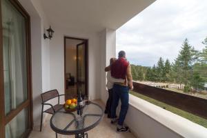a man and woman standing on a balcony looking out the window at Oak Residence Hotel & Relax in Smolyan