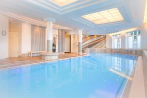 a large swimming pool in a building with a ceiling at Luxuriöses Wellnes Apartment in Bad Essen