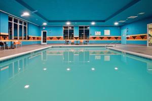 a swimming pool in a gym with blue walls at Holiday Inn Hotel & Suites Gateway, an IHG Hotel in Williamsburg