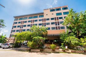 un gran edificio con árboles delante de él en Princess Park Hotel, en Suratthani