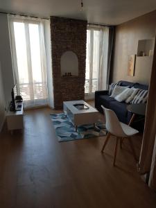 a living room with a couch and a table at appartement renové , quartier historique du panier , centre-ville in Marseille