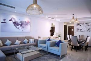 Gulf Executive Hotel & Residence Juffair في المنامة: غرفة معيشة مع أريكة وطاولة