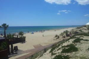 una playa con mucha gente en ella en Cap d'Agde Naturist Héliopolis K 106, en Cap d'Agde