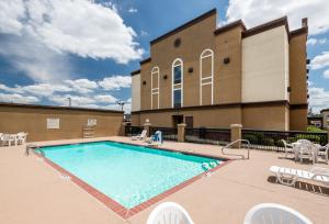 a swimming pool with chairs and a building at Holiday Inn Express & Suites - Grenada, an IHG Hotel in Grenada