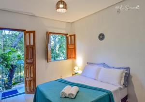 a bedroom with a bed with two towels on it at Chalés Natora in Lençóis