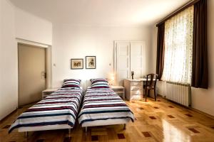 a bedroom with two beds and a desk in it at Vila Regina rooms in Karlovac
