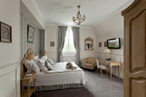 - une chambre avec un lit, un bureau et une télévision dans l'établissement Hôtel Château Tilques, à Tilques