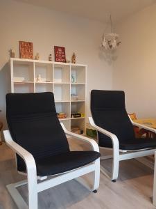 dos sillas sentadas en una habitación con un estante en Sweet family apartments Hamina, en Hamina