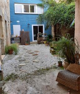 un patio trasero con una casa azul y un camino de piedra en duplex à Samadet, en Samadet