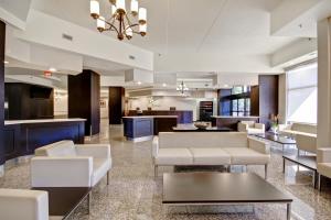 - un hall d'un hôtel avec des tables et des chaises blanches dans l'établissement Holiday Inn Windsor - Ambassador Bridge, an IHG Hotel, à Windsor