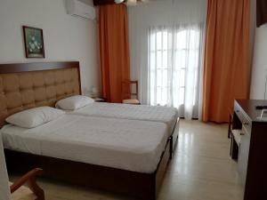 ein Hotelzimmer mit einem Bett und einem Fenster in der Unterkunft Hotel Paradise in Vassilias
