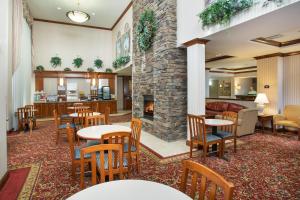 un vestíbulo con mesas, sillas y chimenea en Holiday Inn Express Hotel & Suites Marion, an IHG Hotel, en Marion