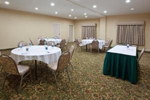una sala de banquetes con mesas y sillas blancas en Holiday Inn Express Hotel & Suites Marion, an IHG Hotel, en Marion