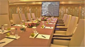 een grote vergaderzaal met een lange tafel en stoelen bij Makkah Hotel in Mekka