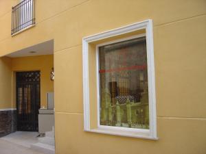 a window on the side of a yellow building at HOTEL PLAZA in Talarrubias