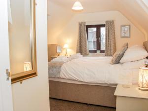 a bedroom with a large bed and a window at Oakland Cottage in Craven Arms