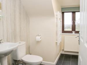 a white bathroom with a toilet and a sink at Oakland Cottage in Craven Arms +24 photos