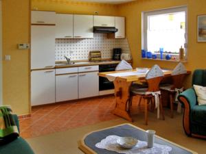 a kitchen with a table and a kitchen with white cabinets at Ferienhaus Ursula in Malchow