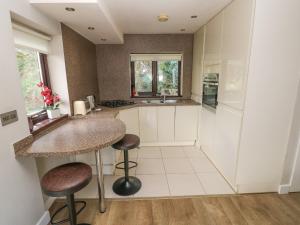 a kitchen with a counter and stools in it at The Garden Flat in Saundersfoot