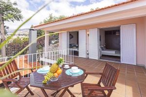 eine Terrasse mit einem Tisch und Obst darauf in der Unterkunft Funchal Bay View Villa by Homie in São Gonçalo