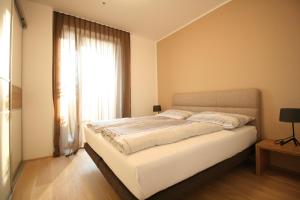 een slaapkamer met een wit bed en een raam bij Your Living Vienna CBD in Wenen