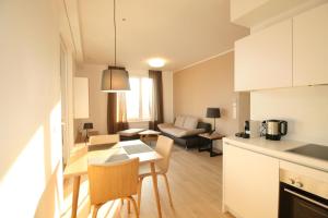 een keuken en een woonkamer met een tafel en stoelen bij Your Living Vienna CBD in Wenen