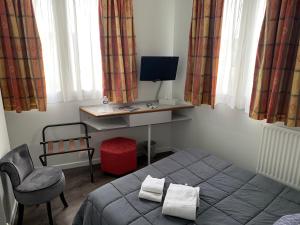 um quarto com uma cama, uma secretária e uma cadeira em Picardy Hôtel-Gare du Nord em Paris