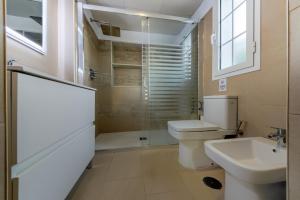 a bathroom with a toilet and a sink and a shower at Villas Flamenco Beach Conil in Conil de la Frontera