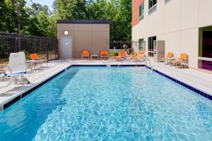 a swimming pool with chairs and a building at Holiday Inn Express & Suites - King George - Dahlgren, an IHG Hotel in Alden