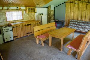 uma cozinha com uma mesa de madeira e um fogão em CHATA JURAJ em Mlynky 