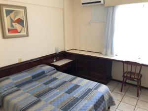 سرير أو أسرّة في غرفة في Hotel Residencial Itapema