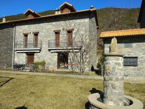 an old stone house with a statue in front of it at Casa Sierra de Limes 4 in Biescas