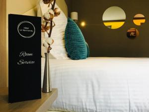 a hotel room with a bed with a room survey sign next to it at Hôtel Le Normandy - Maison Tassoni in Vernon