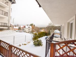 Apartament z balkonem ze śniegiem na ziemi w obiekcie VacationClub – Dworcowa 1A Apartament 3 w Szklarskiej Porębie