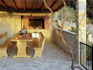 een patio met een tafel en stoelen en een open haard bij Holiday house Tender near Trogir, jacuzzi in Sevid