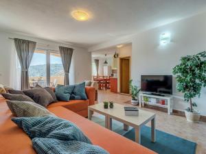 ein Wohnzimmer mit Sofa und Fernseher in der Unterkunft Holiday house Tender near Trogir, jacuzzi in Sevid