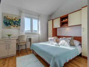 ein Schlafzimmer mit einem Bett, einem Schreibtisch und einem Tisch in der Unterkunft Holiday house Tender near Trogir, jacuzzi in Sevid + 13 Fotos