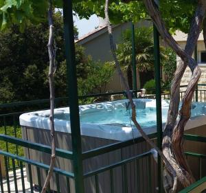 ein Whirlpool in einem Zaun mit einem Baum in der Unterkunft Holiday house Tender near Trogir, jacuzzi in Sevid