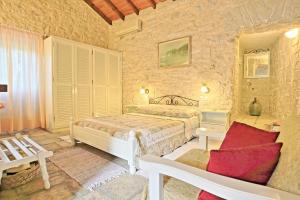 a bedroom with a bed and a chair in a room at Korinas Cottage: Stone cottage close to the beach in Agní