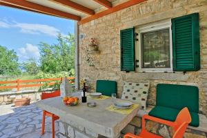 a table and chairs on the patio of a house at Korinas Cottage: Stone cottage close to the beach in Agní