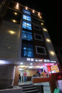 a tall building with people standing outside of it at night at Hotel BG Inn in Bangalore
