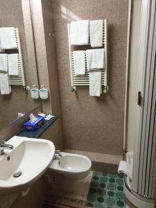 ein Bad mit einem Waschbecken, einem WC und Handtüchern in der Unterkunft Hotel Ristorante Bagnaia in Viterbo