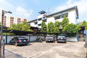 un estacionamiento con tres camiones estacionados frente a un edificio en Riski Residence Bangkok-noi - Wasit Apartment, en Bangkok