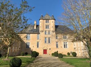 un vieux château avec une porte rouge au milieu dans l'établissement Château d'Avanton, à Avanton