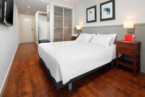 a bedroom with a large white bed and a wooden floor at HG Cerler in Cerler